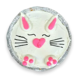 Bunny Cookie Cake decorated with white and pink buttercream on a deep dish chocolate chip cookie cake, designed for Easter celebrations.