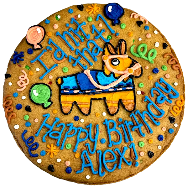 Giant chocolate chip cookie cake, decorated in a bright fiesta theme with a frosted piñata and text that reads "I'd hit that, happy birthday Alex".