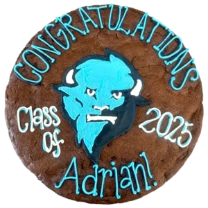 Giant chocolate-chocolate chip flavored cookie cake, decorated with bright frosting celebrating graduation.
