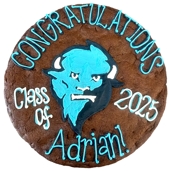Giant chocolate-chocolate chip flavored cookie cake, decorated with bright frosting celebrating graduation.