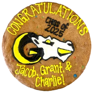 Giant M&M flavored cookie cake, decorated with bright frosting celebrating graduation.