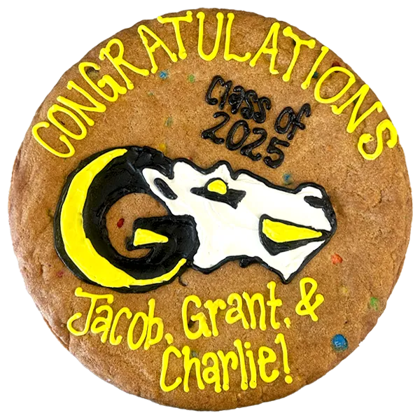 Giant M&M flavored cookie cake, decorated with bright frosting celebrating graduation.