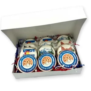 Box of custom logo cookies from The Colorado Cookie Company featuring blue and orange branded designs, neatly packaged in a white bakery box with red, white, and blue filler paper.