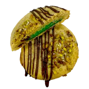 Our homemade pistachio cookie butter stuffed between two chocolate chip cookies, rolled in chopped pistachios and sea salt, and then finished off with an extra drizzle of milk chocolate!