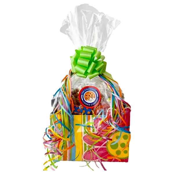 Themed Cookie Variety Box from The Colorado Cookie Company featuring a colorful striped gift box with playful polka dot accents, wrapped in clear cellophane and topped with a bright green bow. The box is filled with an assortment of fresh-baked cookies and tied with multicolored curling ribbons for a festive presentation.