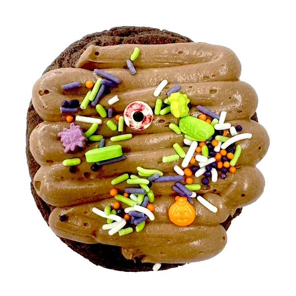 Giant chocolate boneyard cookie topped with chocolate mousse, candy bones, candy eyes, and a tombstone decoration for Halloween.