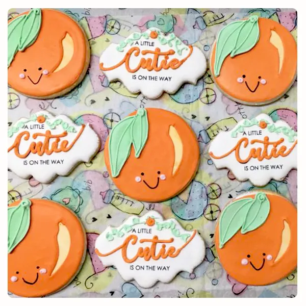 Custom “A Little Cutie Is on the Way” baby shower sugar cookies with smiling oranges and personalized decorations