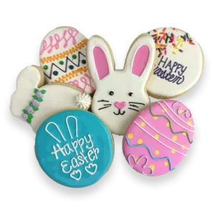 Hand-decorated Easter sugar cookies with royal icing, including a bunny face, decorated eggs, a carrot, and pastel spring designs.