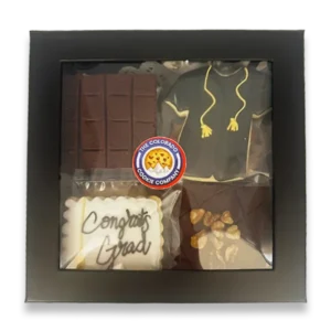 Graduation Gift Box by The Colorado Cookie Company featuring a decorated graduation gown sugar cookie, Congrats Grad iced cookie, chocolate fudge brownies, and classic cookies in a black gift box