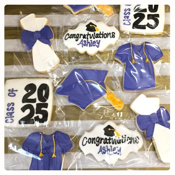Personalized graduation decorated cookies featuring graduation caps, diplomas, class year, and custom graduate name