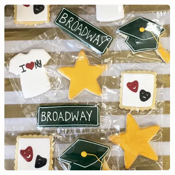 Custom New York themed decorated sugar cookies featuring Broadway signs, graduation caps, stars, and personalized designs